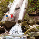 Young boys enjoying visiting a waterfall.