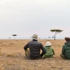 Family looking out over the savannah, Kenya.