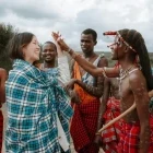 Girl meeting members of a Masai tribe in their village, Kenya.