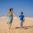Mother and son on the sand dunes of the Sahara Desert in Morocco