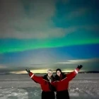 Two people enjoying the Northern Lights in Sweden