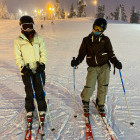 Siblings skiing at night in Finland