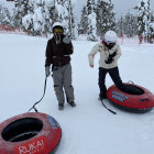 Siblings snow-tubing in Finland