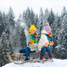 Siblings on a toboggan ride in Finland