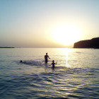 Family in the sea at sunset in Crete, Greece