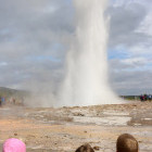 Children watching geysir erupt in Iceland