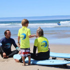 Family learning to surf in Portugal