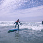 Girl standing up on a surf board in Portugal