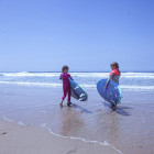 Two young girls learning to surf in Portugal