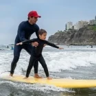 Child learning to surf in Lima, Peru
