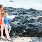 Family and marine iguana in the Galapagos Islands