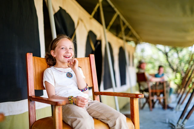 Girl sitting on a chair outside a camp in Botswana