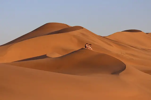Children relaxing on a Namibian sand dune.