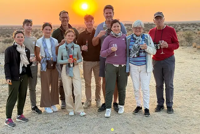 Family photo enjoying drinks at sunset in Namibia.