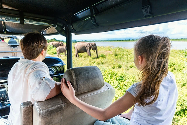 Father & daughter on safari watching elephants in Udawalawe National Park, Sri Lanka