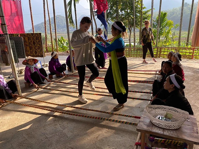 Girl dancing with locals in Mai Chau village, Vietnam.