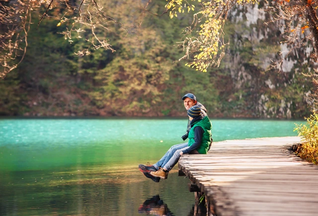 Father & son sitting on a boardwalk in Plitvice National Park, Croatia