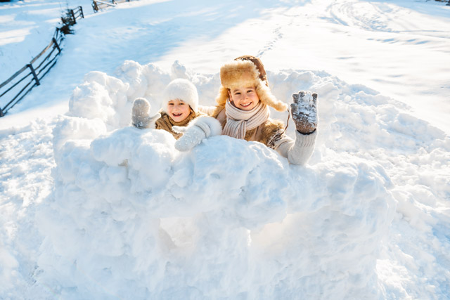 Siblings building an igloo in Finland