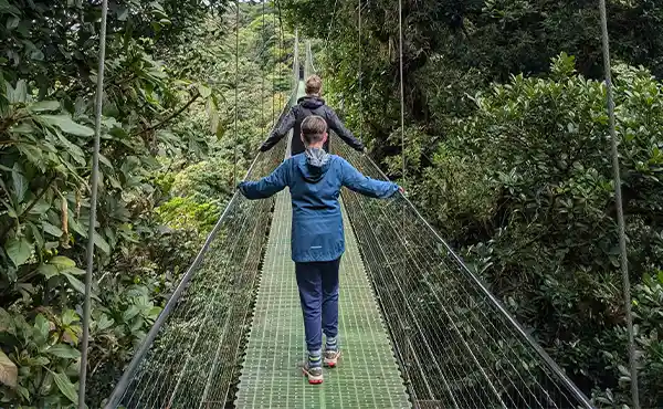 Family walking across the hanging bridge in Costa Rica,
