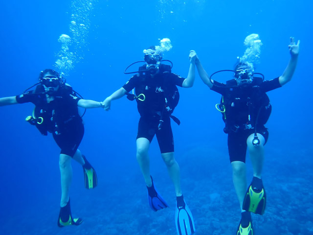 Group diving underwater in Aqaba, Jordan.