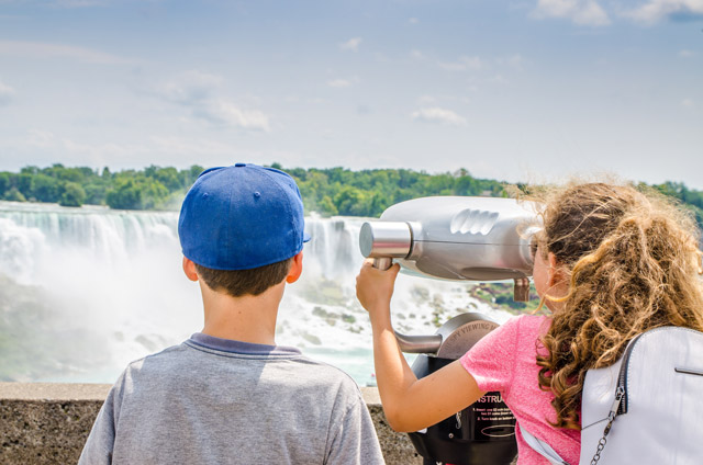 Children looking through a telescope at Niagara Falls in Canada