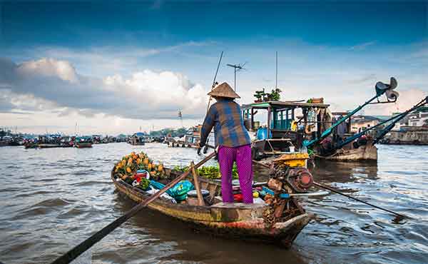 Vietnamese man selling produce in floating market at Cai Rang