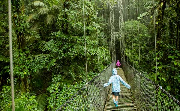 Girls walking across hanging bridge in Costa Rica